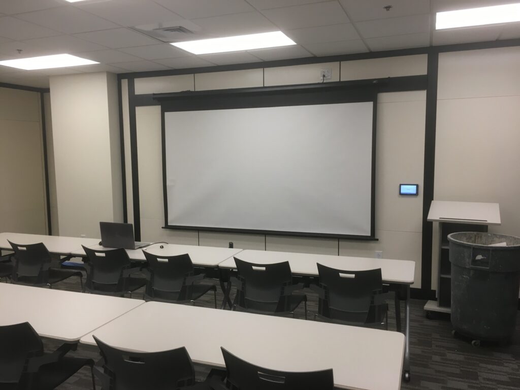 CVN Conference room with dropped projector screen and Extron controls.
